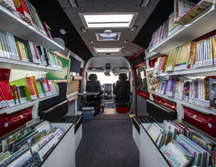 inside of Calgary Public Library's bookmobile. Shelves of books in a van. 